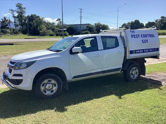 White pest control truck parked on grass, blue sky background. Text on the truck reads 