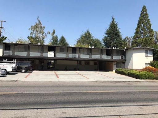 A large apartment building with a parking lot in front of it.
