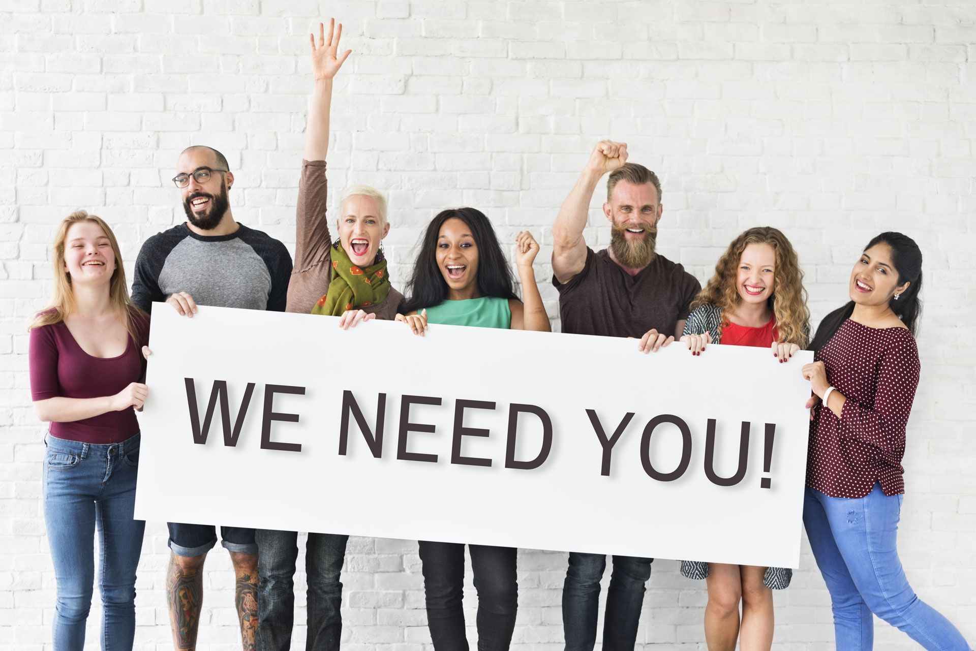 A group of people are holding a sign that says `` we need you ''.