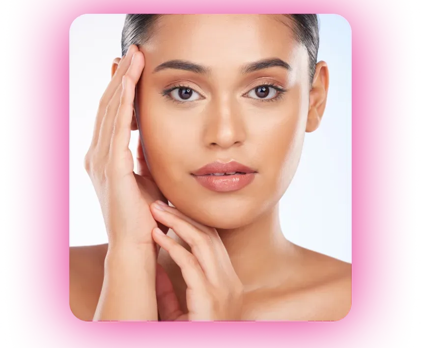 Woman with hands on face, looking at camera. Pink and neutral makeup with soft lighting.
