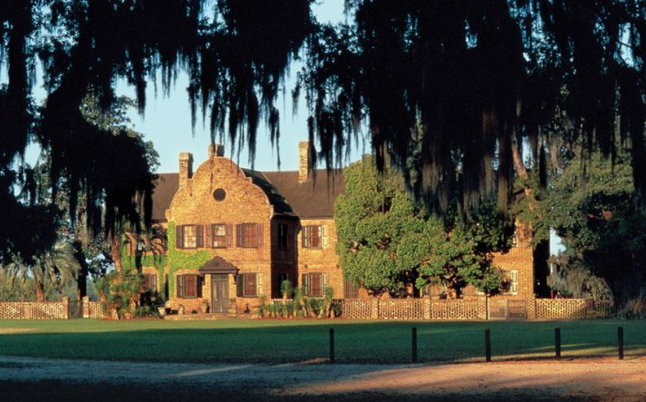 A large house with spanish moss on the side of it