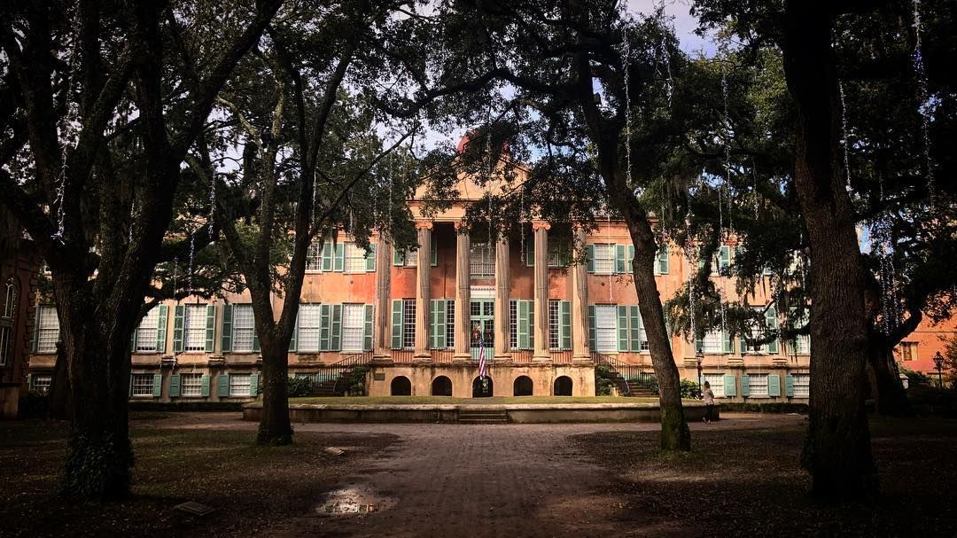A large building with a lot of windows is surrounded by trees.