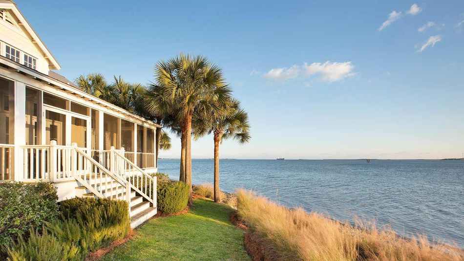 A house with a screened in porch overlooking the ocean.