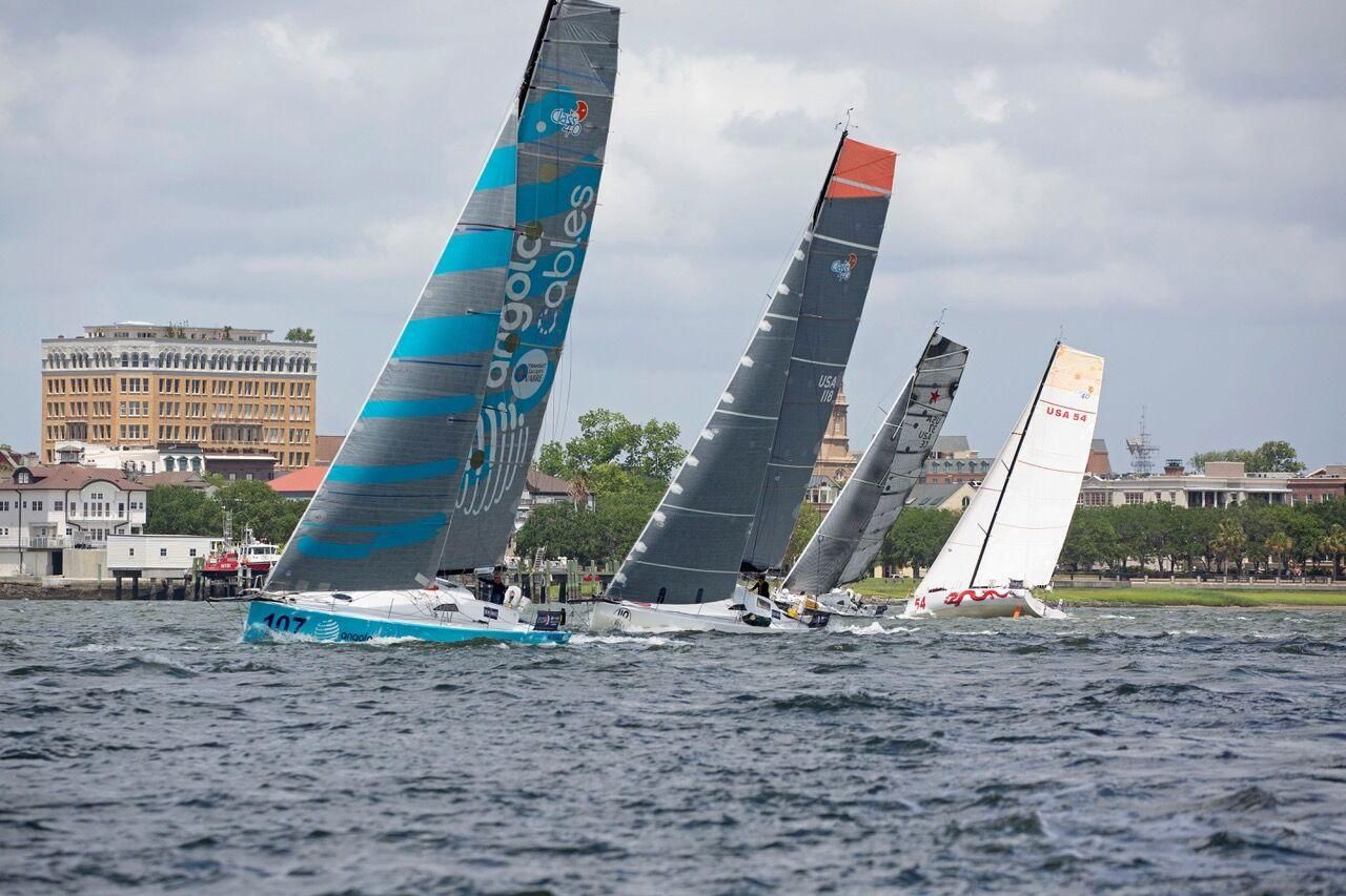 A group of sailboats are racing on a body of water.