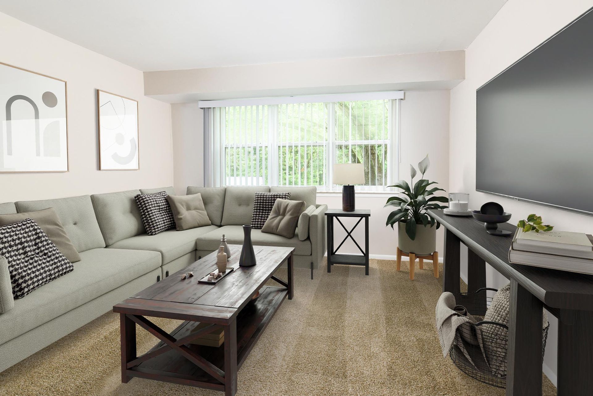 L-shaped beige living room with a sofa, coffee table, and a large window with vertical blinds at Liberty Pointe in Newark, DE.