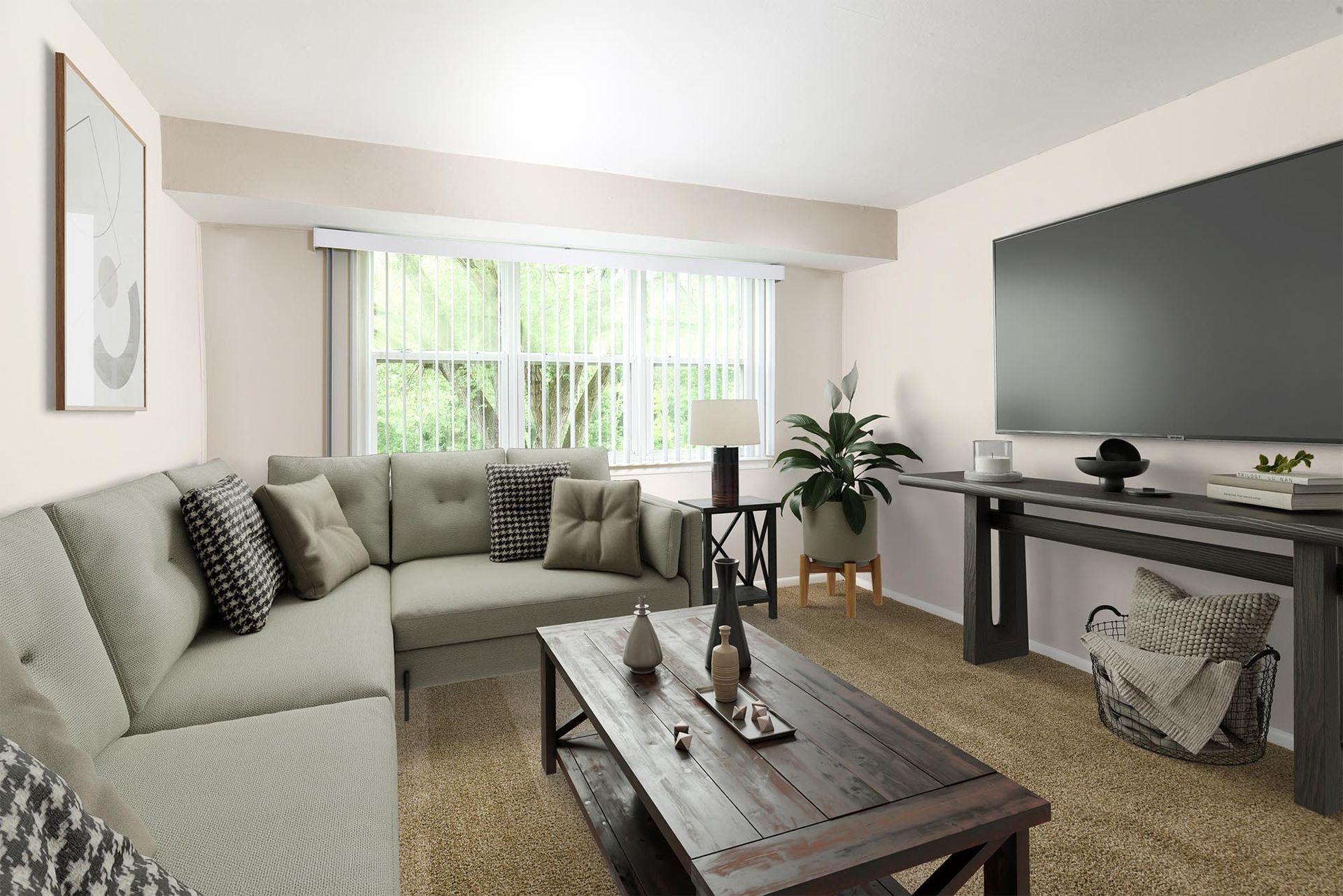 Living room in a modern apartment with a gray sectional, coffee table, and a large window at Liberty Pointe in Newark, DE.