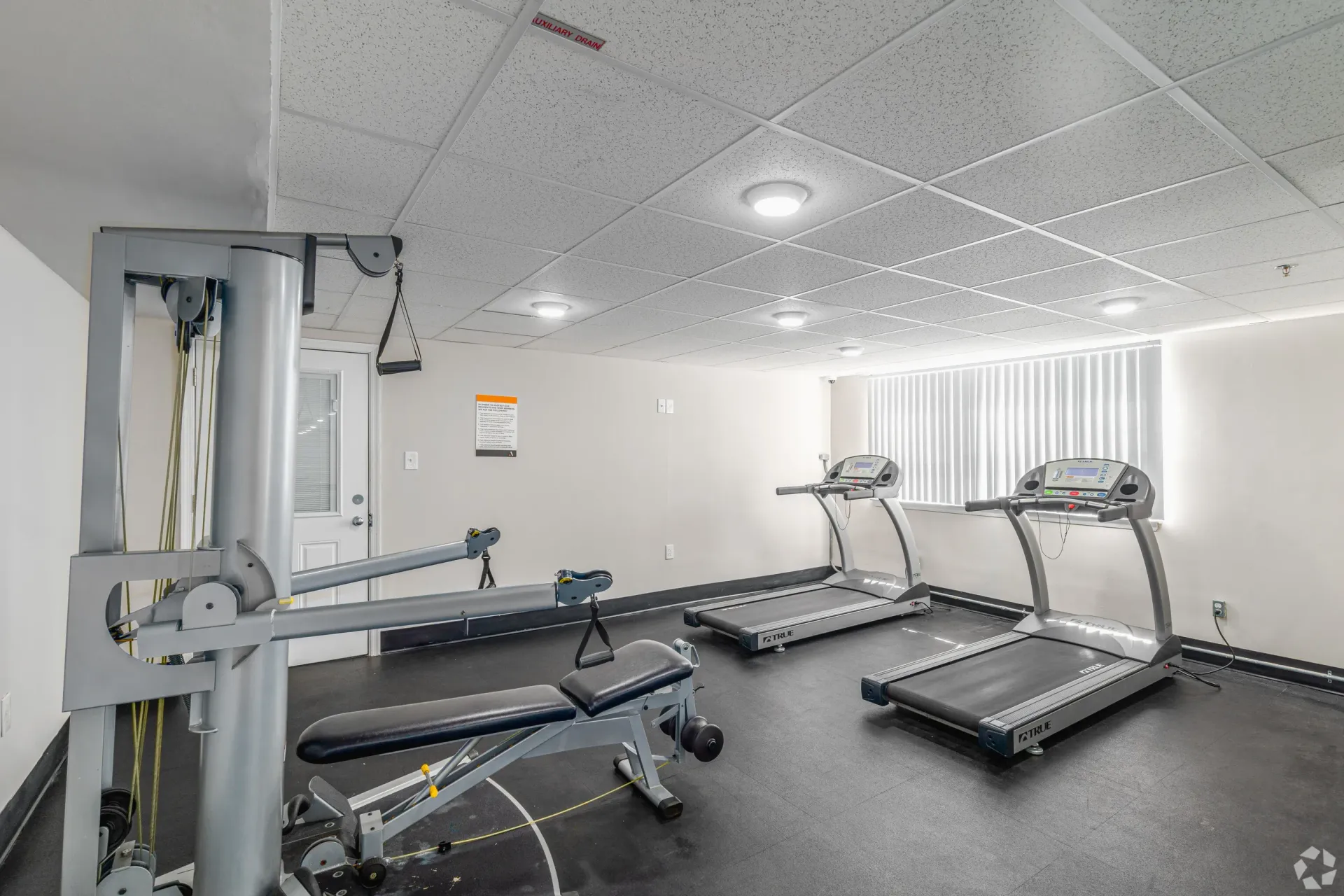 Compact community gym with two treadmills and a weight bench at Liberty Pointe in Newark, DE.