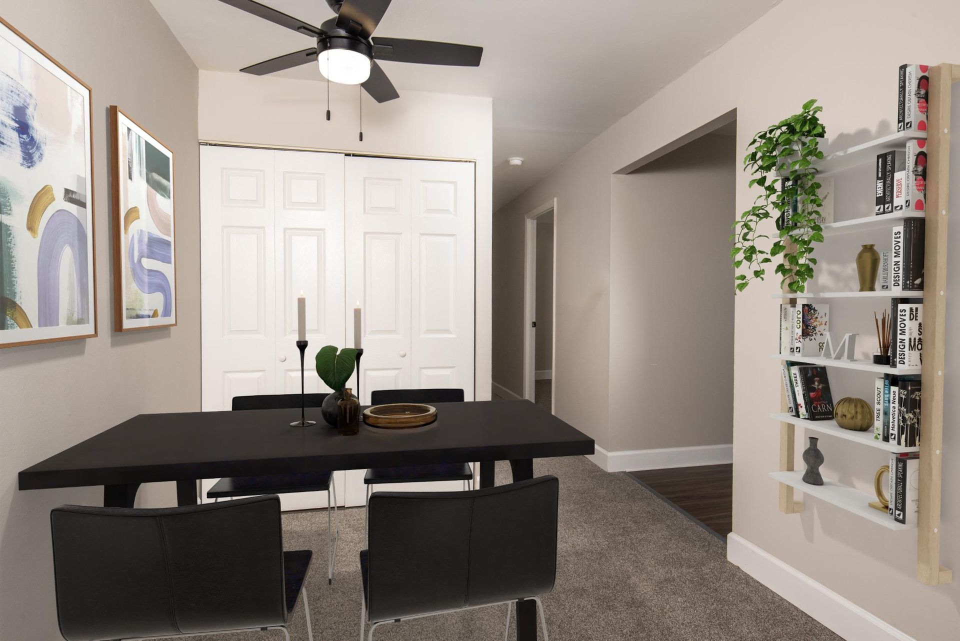Dining area with a black table, four chairs, abstract art, a ceiling fan, and a bookshelf at Liberty Pointe in Newark, DE.