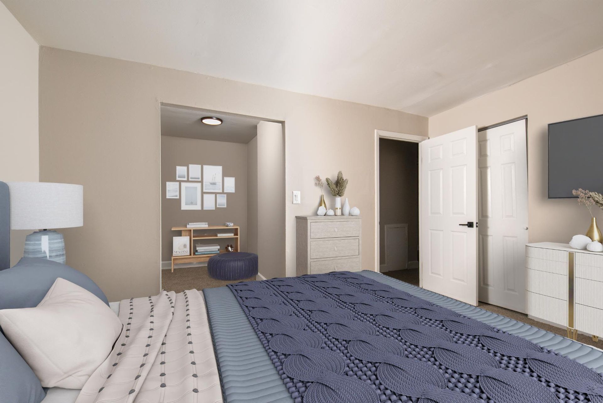 Bedroom in an apartment with a bed, dresser, lamp, and doorway at Liberty Pointe in Newark, DE.