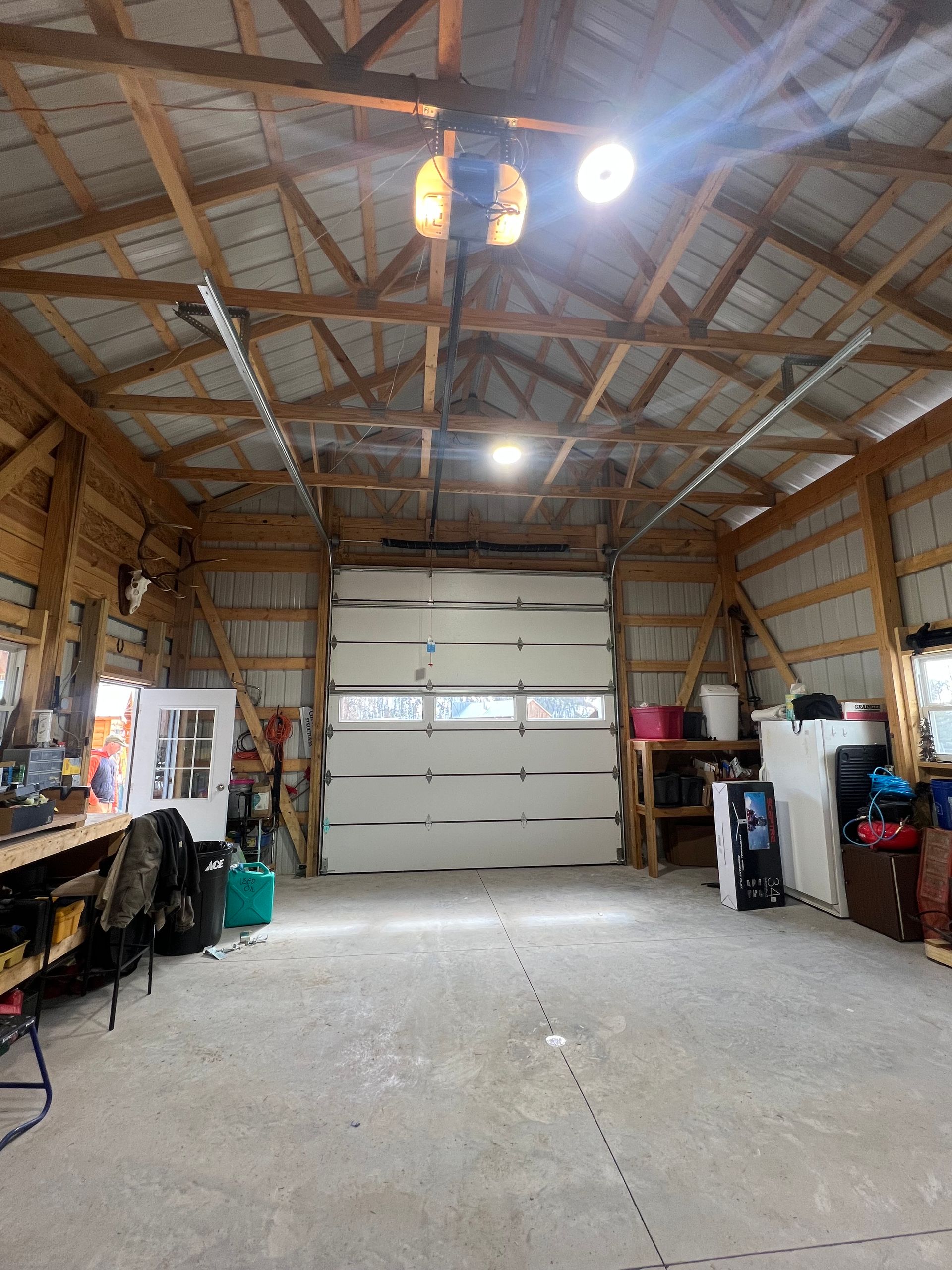 A garage with a large garage door and a ceiling fan