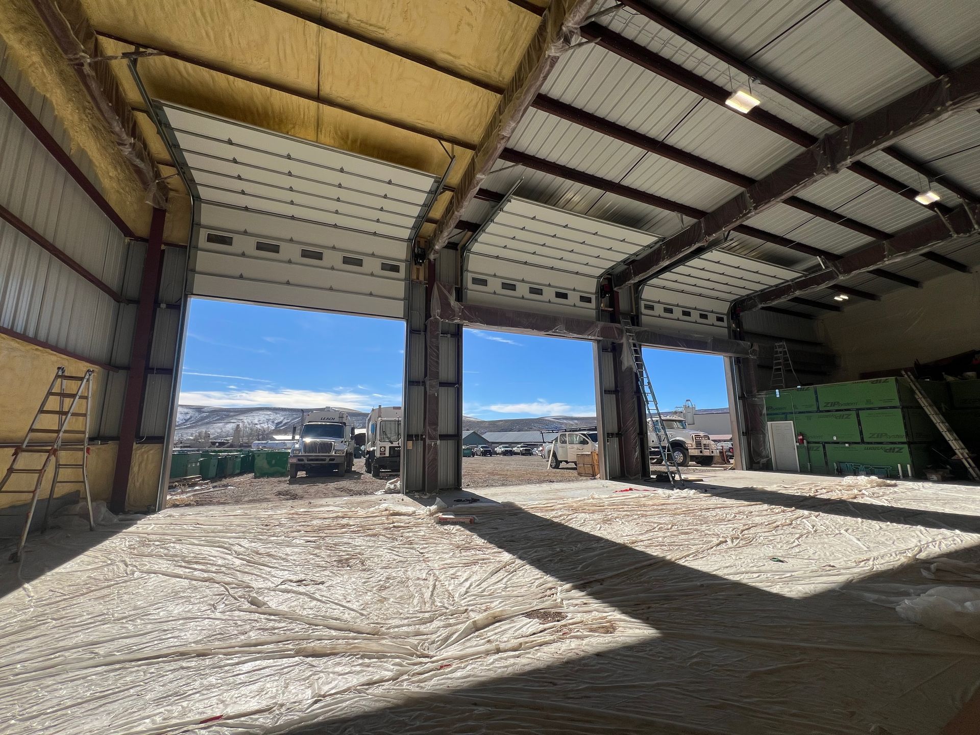 A large warehouse with a large garage door open.