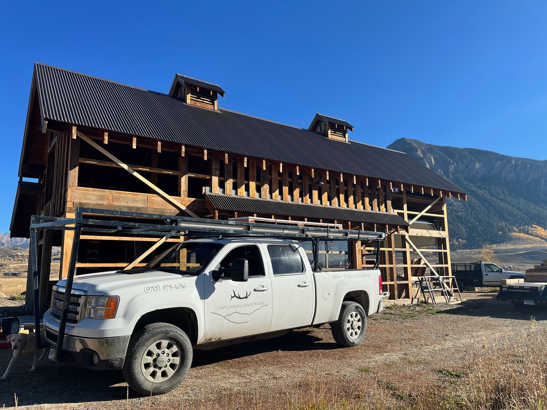 A white truck is parked in front of a building under construction.