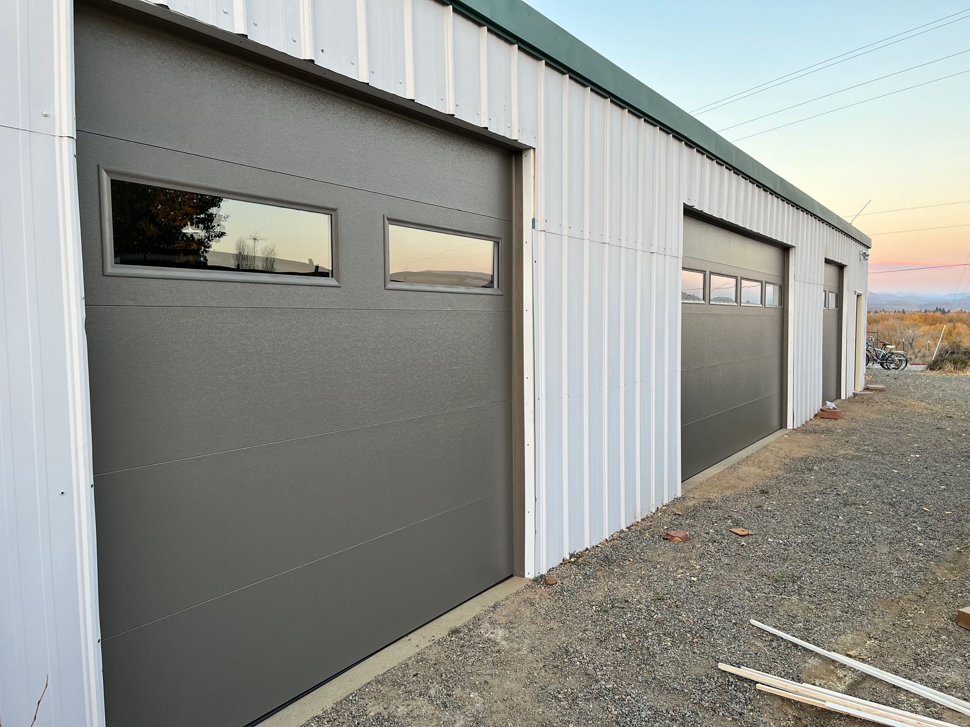 A garage with a black garage door and a brick wall.
