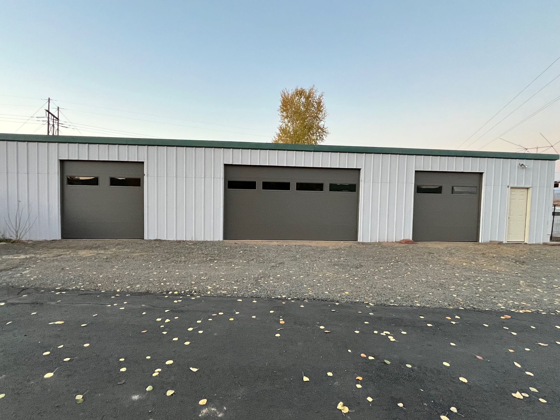 A garage with a black garage door and a brick wall.