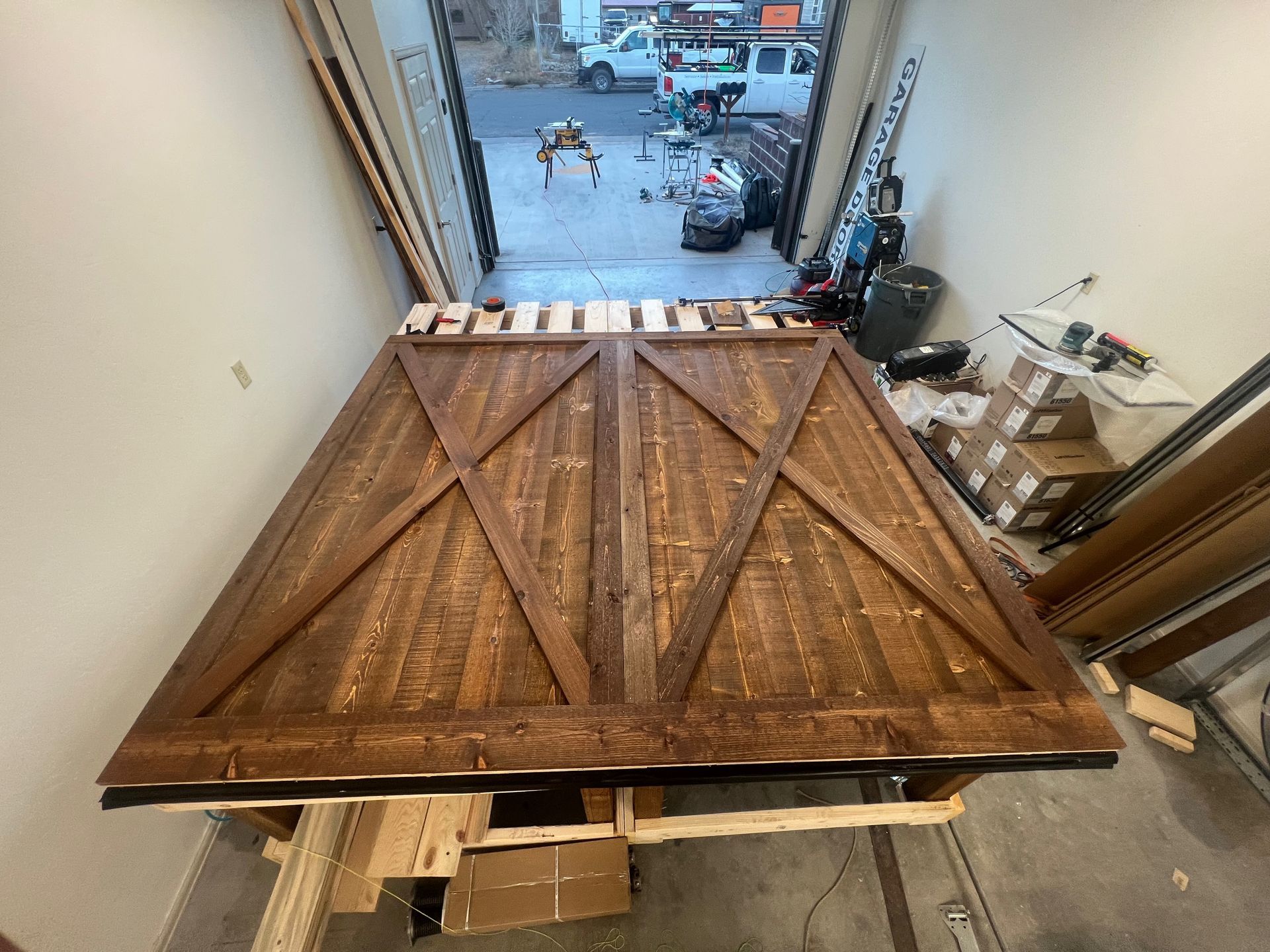 A large wooden table is sitting in a garage.