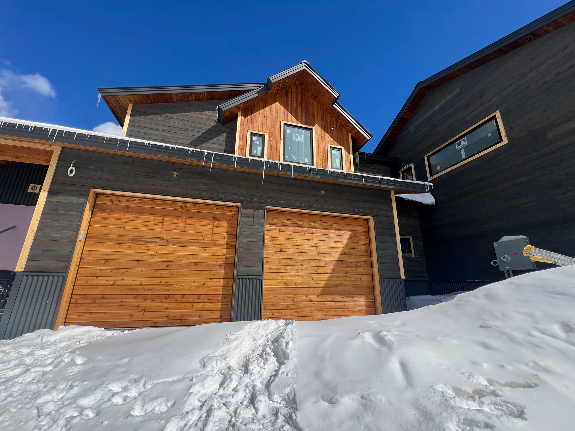 A house with a garage door and a wooden roof.