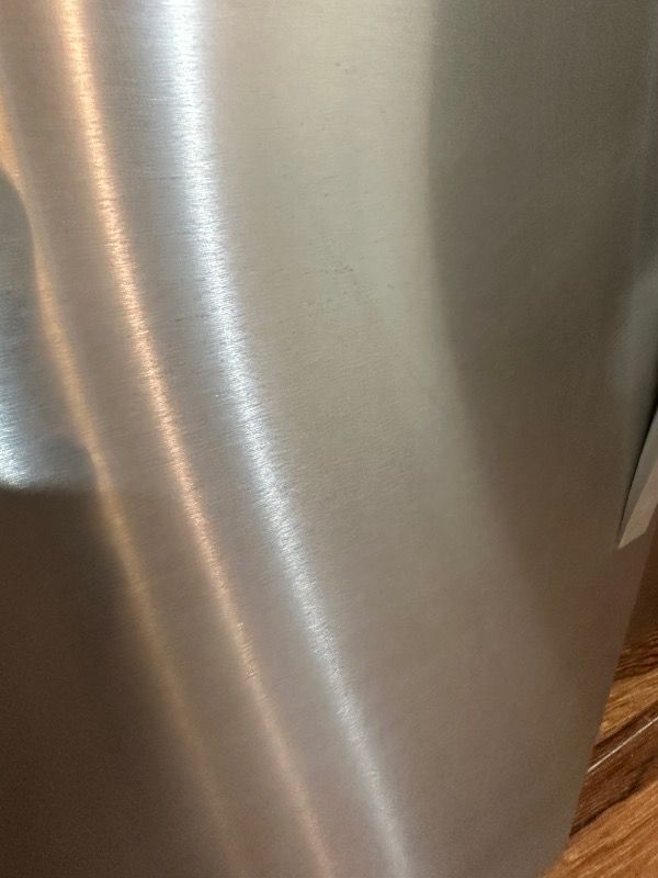 a close up of a newly polished stainless steel refrigerator door .