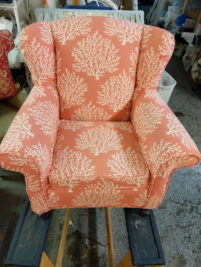 Coral-colored armchair with white coral pattern in workshop setting.