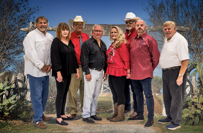 A group of people standing next to each other in front of a bridge.