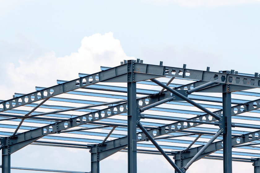 A metal structure is being built with a blue sky in the background.