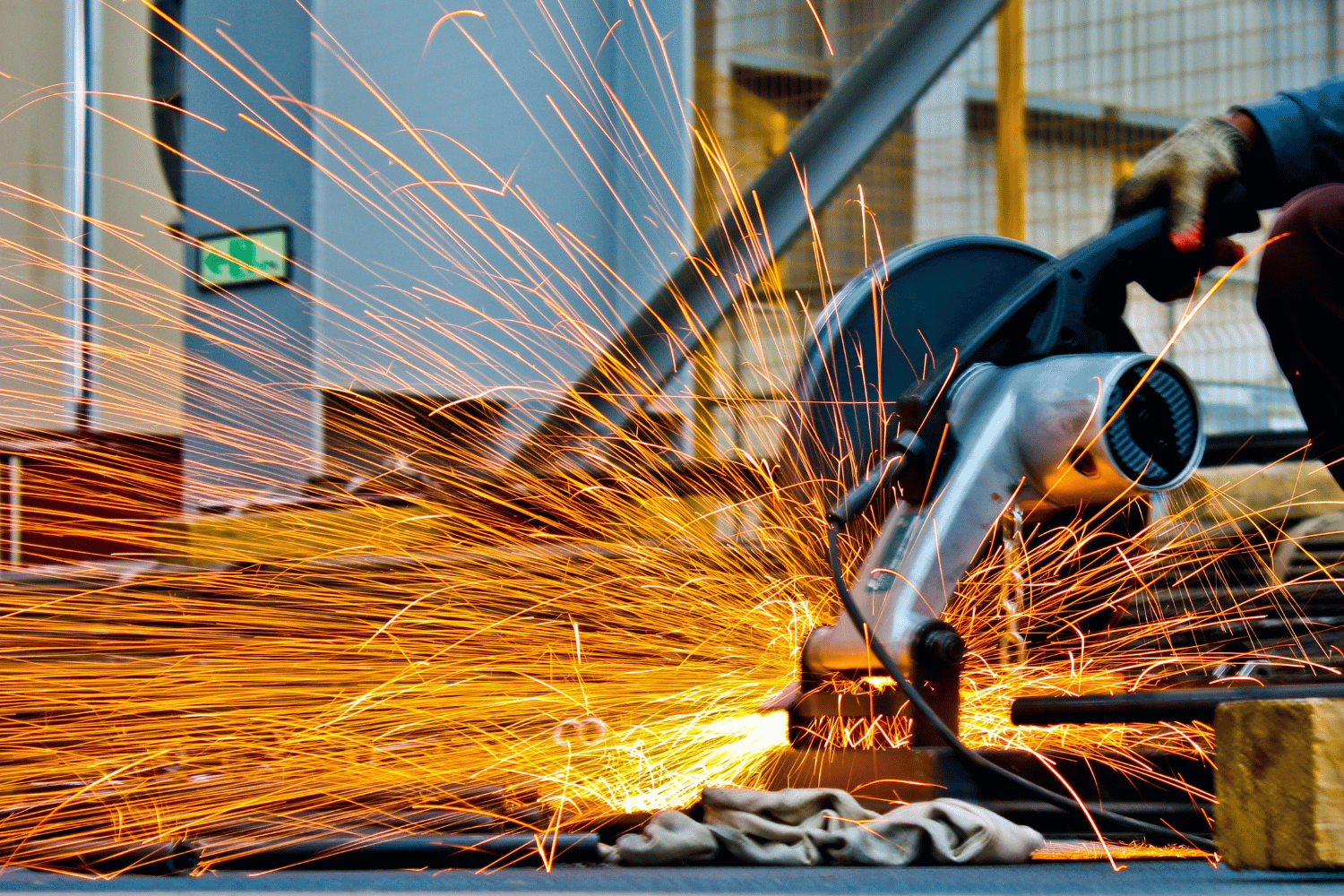 A person is using a circular saw to cut a piece of metal.