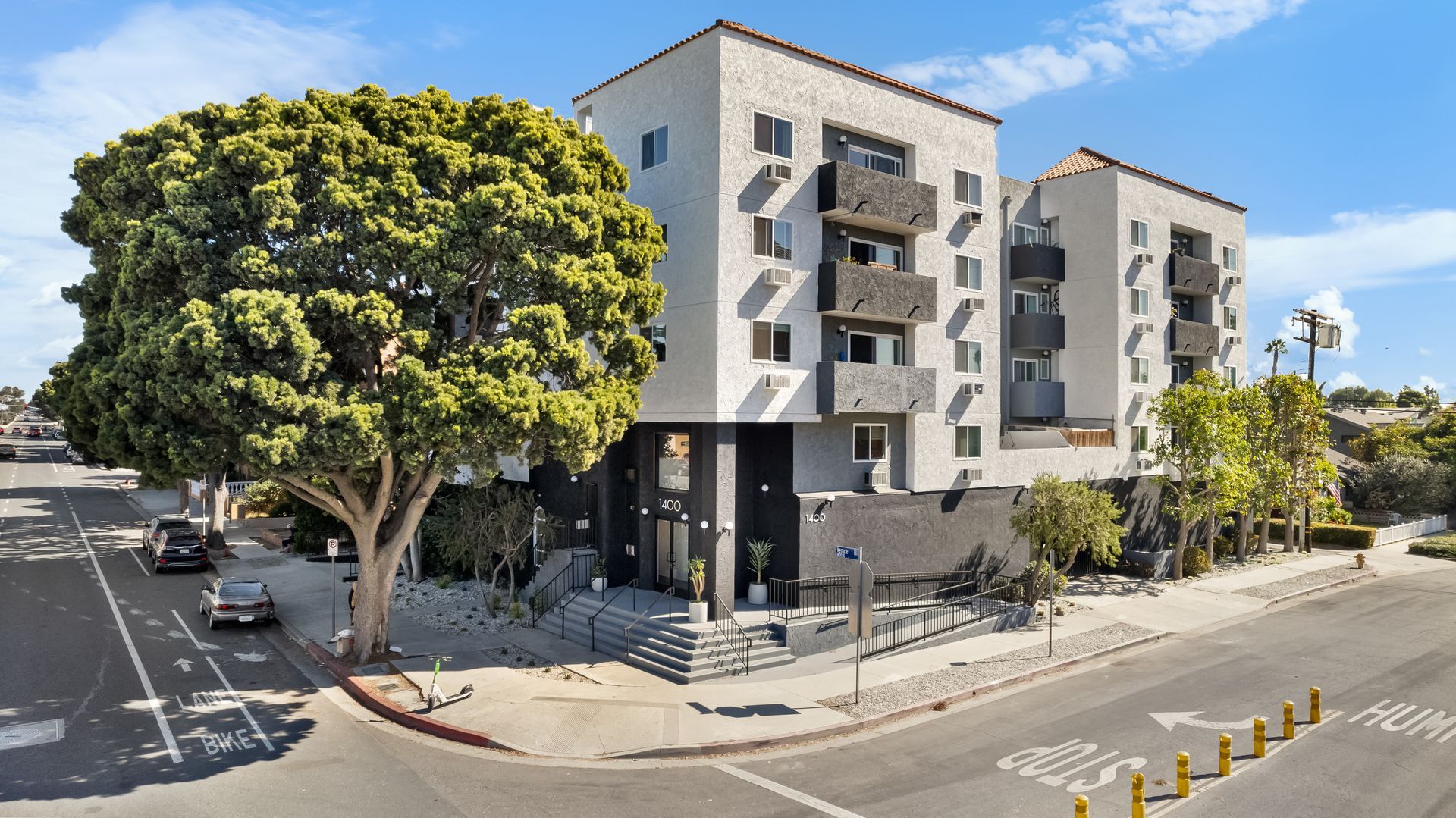 An aerial view of an apartment building with cars parked in front of it