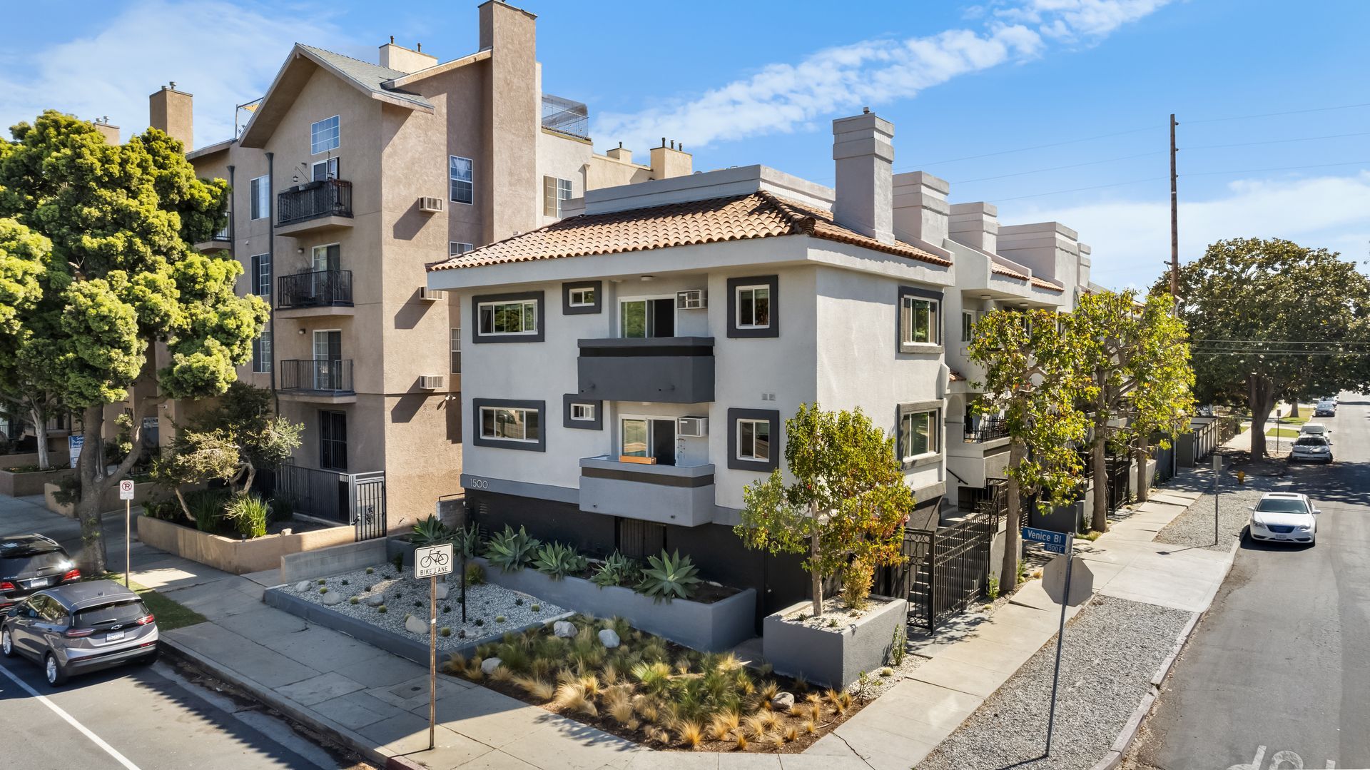An aerial view of an apartment building with cars parked in front of it