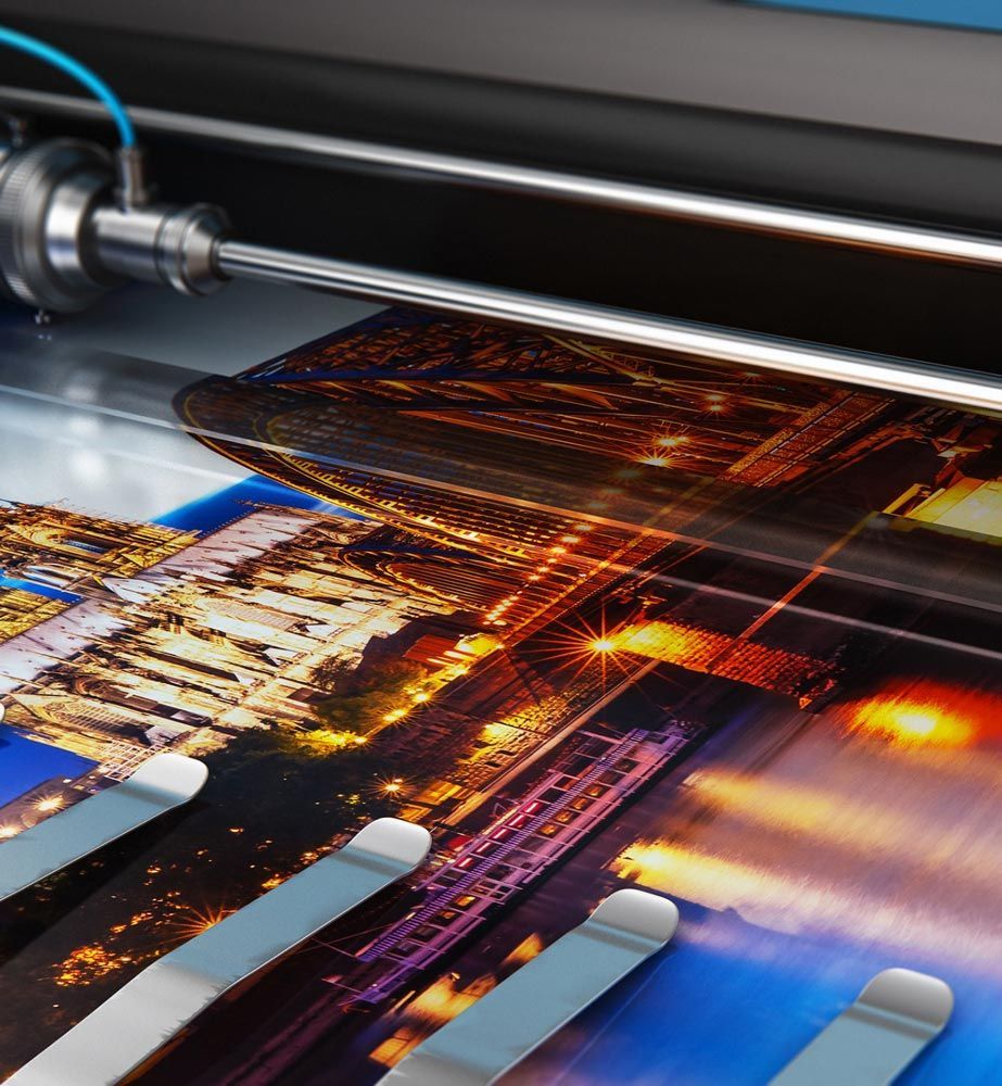 Large format printer laminating a colorful cityscape print.