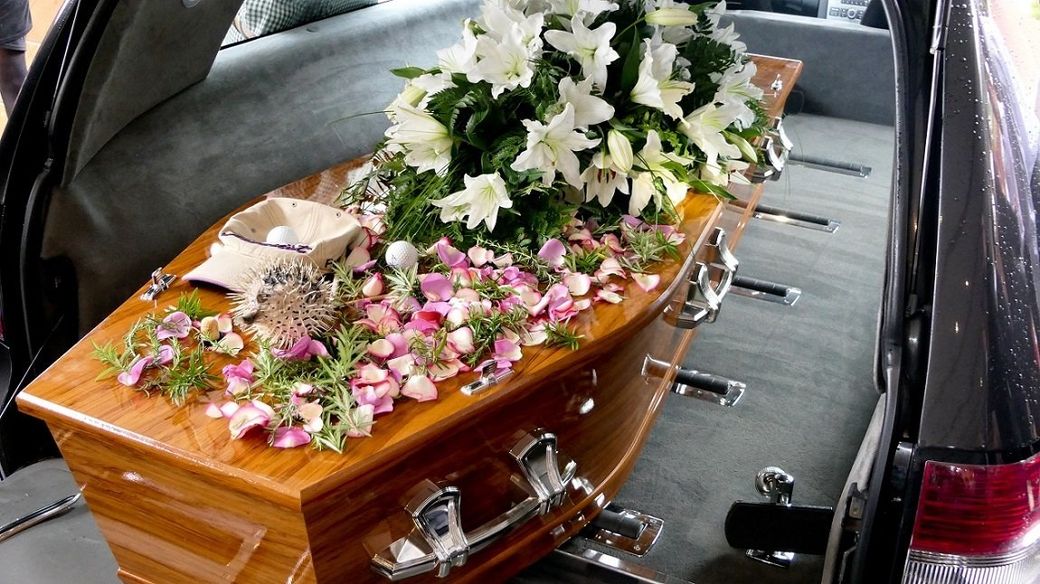 trasporto di un cofano funebre con cuscino di fiori