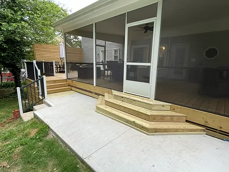 Wooden accessible ramp and steps leading to a screened porch with sliding glass doors