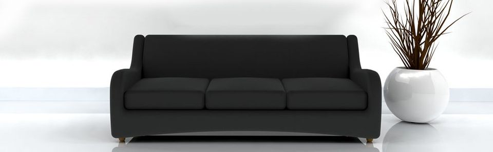 black sofa in a white room with a white round plant pot to the side