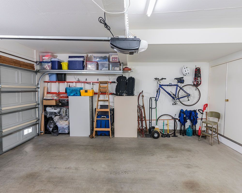 An empty garage with a bicycle hanging on the wall.