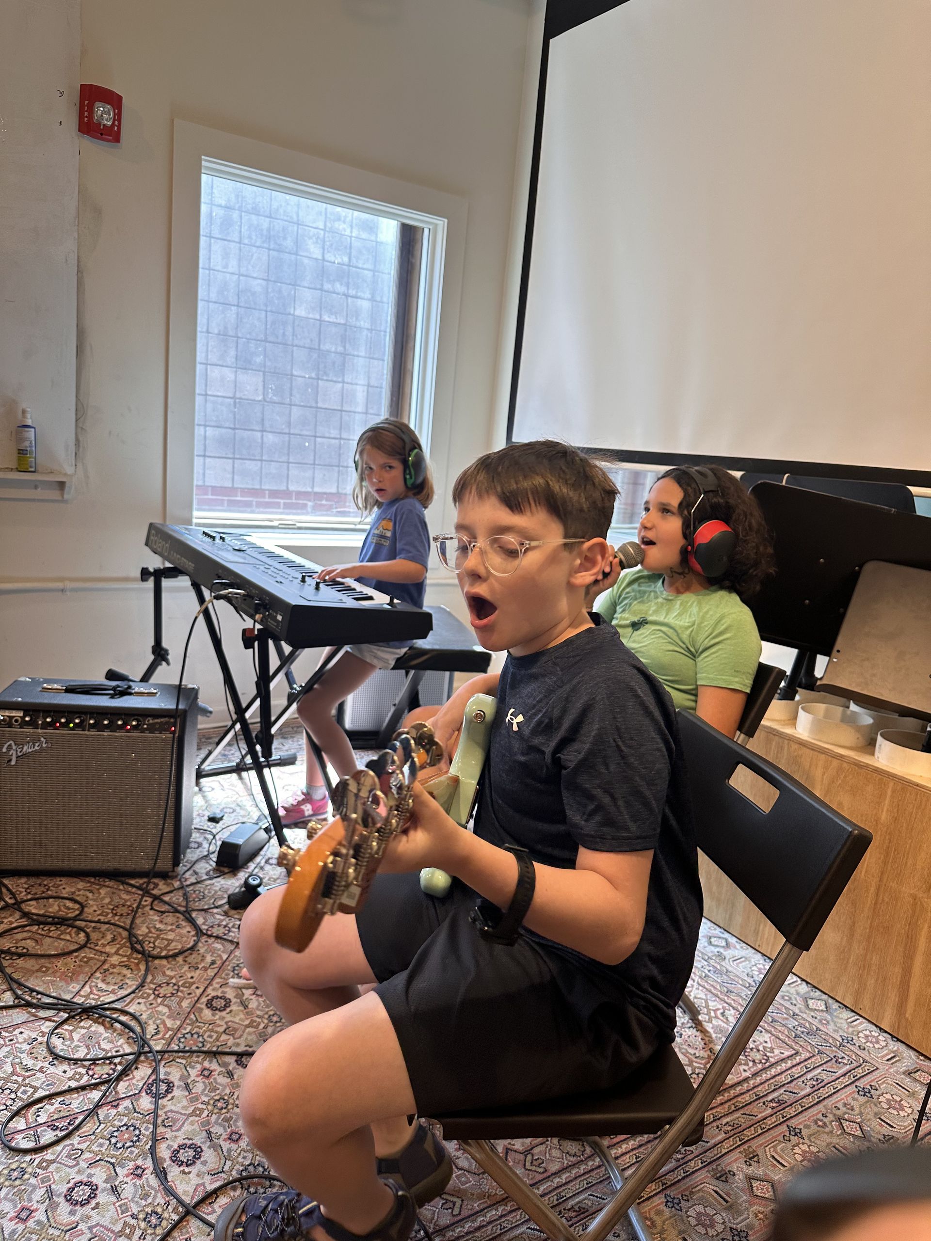 Two young boys are sitting on a cardboard box painting