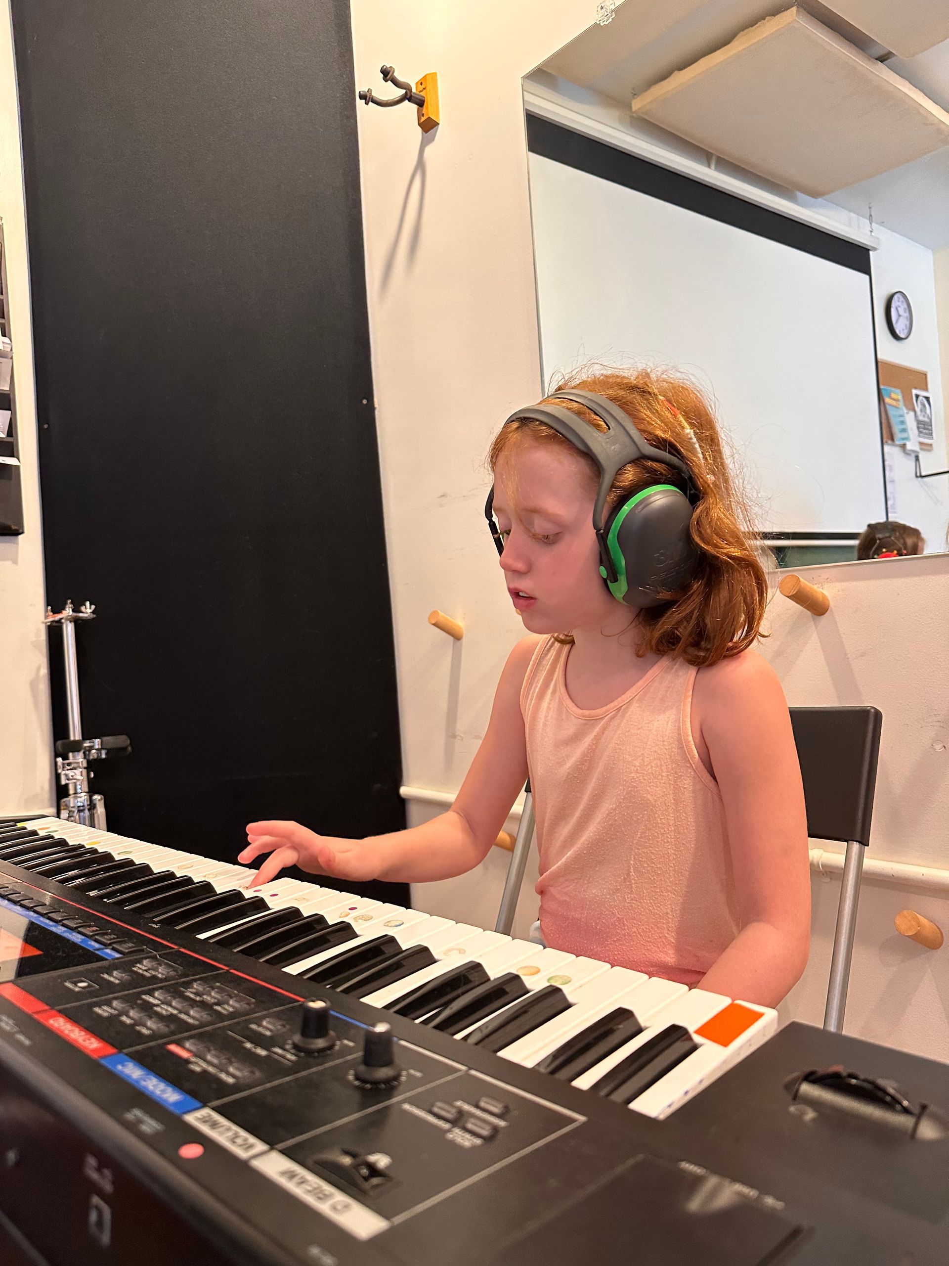 A young boy playing drums with a shirt that says we frighten