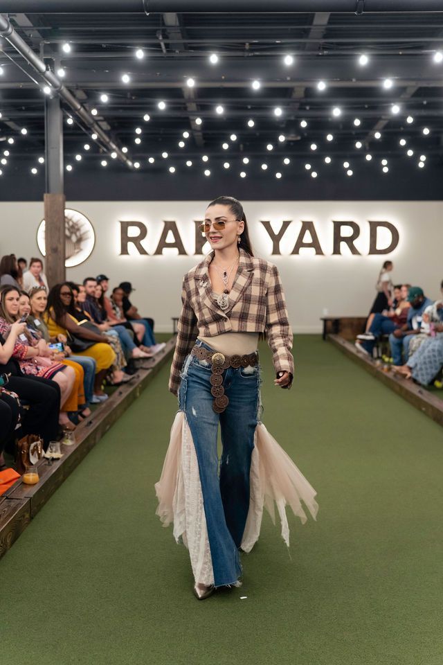 Model walks runway Fashionable outfit: plaid jacket, wide-leg jeans with lace.