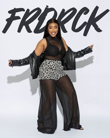 Woman in sheer black outfit, arms outstretched, smiling. Text