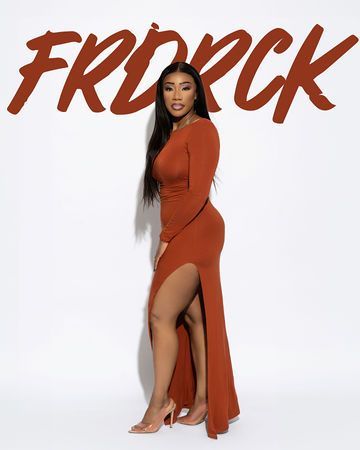 Woman in long-sleeved, rust-colored dress with high slit, standing against white background.