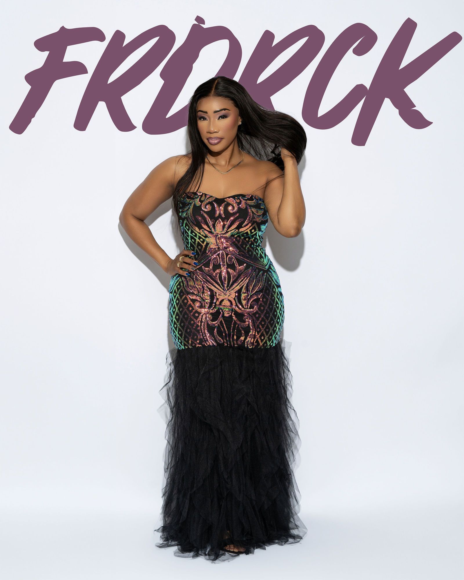 Woman in a sparkly, feathered gown, posing against a white background;