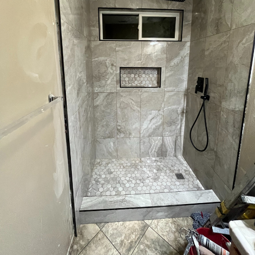 A bathroom with a walk in shower and a window.