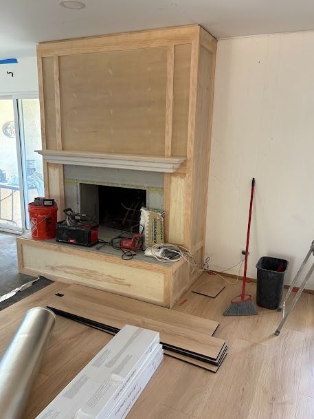 Fireplace under construction with unfinished wood paneling and tools.