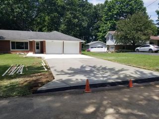 A concrete driveway is being built in front of a house.