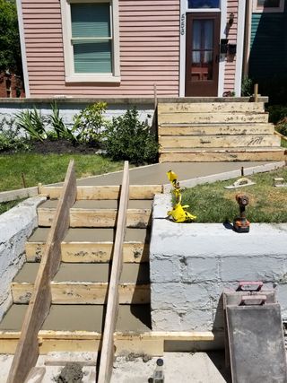 A wooden ramp is being built in front of a house.