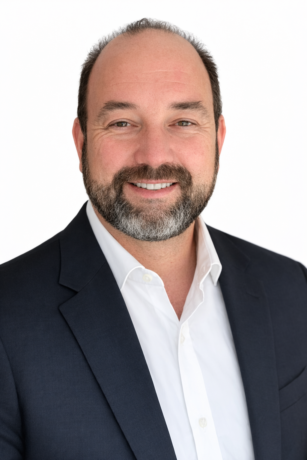 Man in suit smiling, with striped tie against light background.