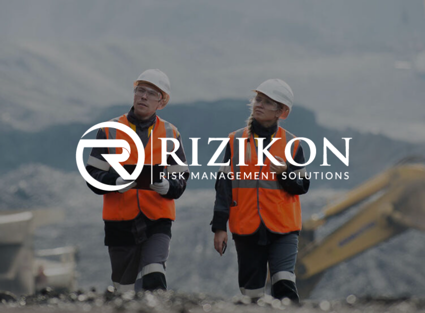Two workers in safety vests and hard hats in a construction area; 