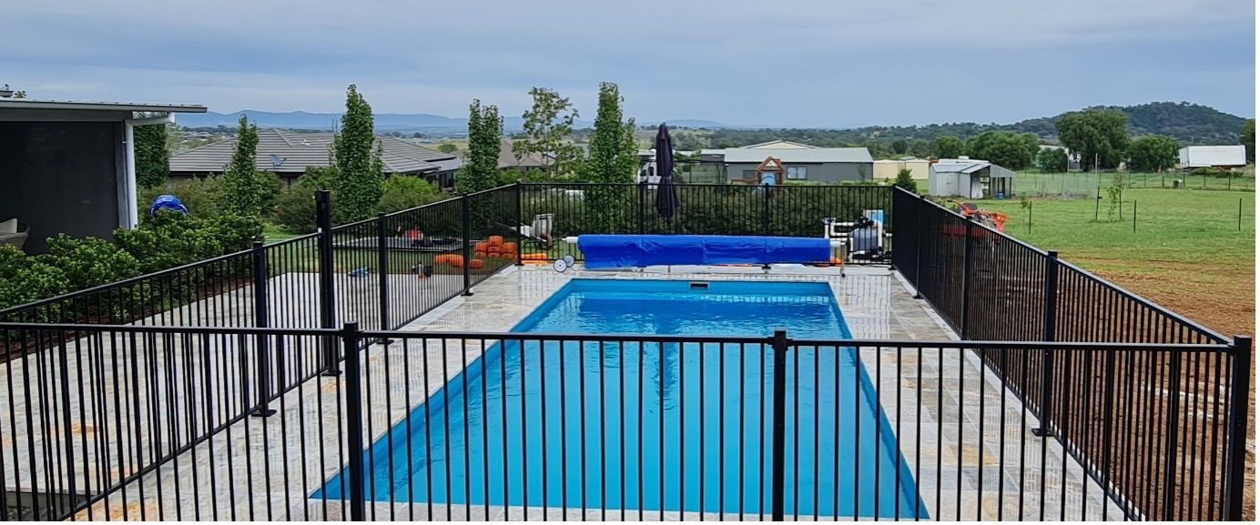 A Swimming Pool With A Roller On The Side Of It — Pool Builder in Moore Creek, NSW