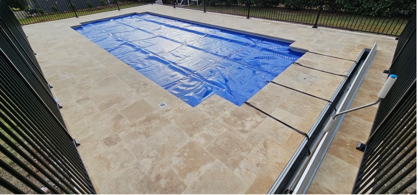 A Swimming Pool With Large Pool Cover On It — Pool Builder in Moore Creek, NSW