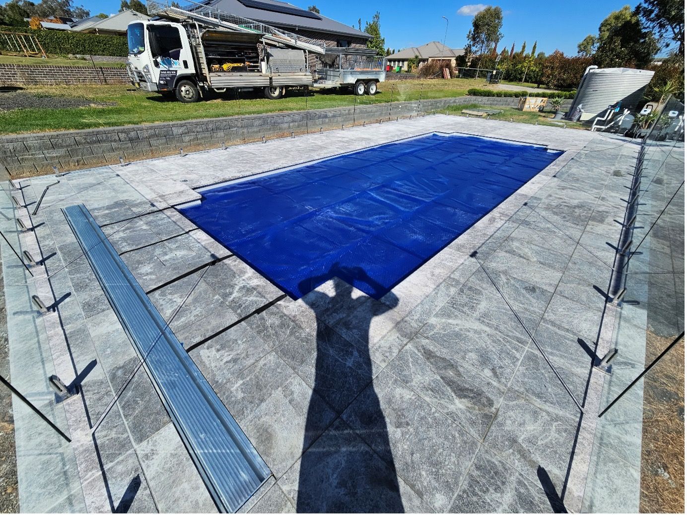 A Swimming Pool With A Blue Cover On It — Pool Builder in Moore Creek, NSW