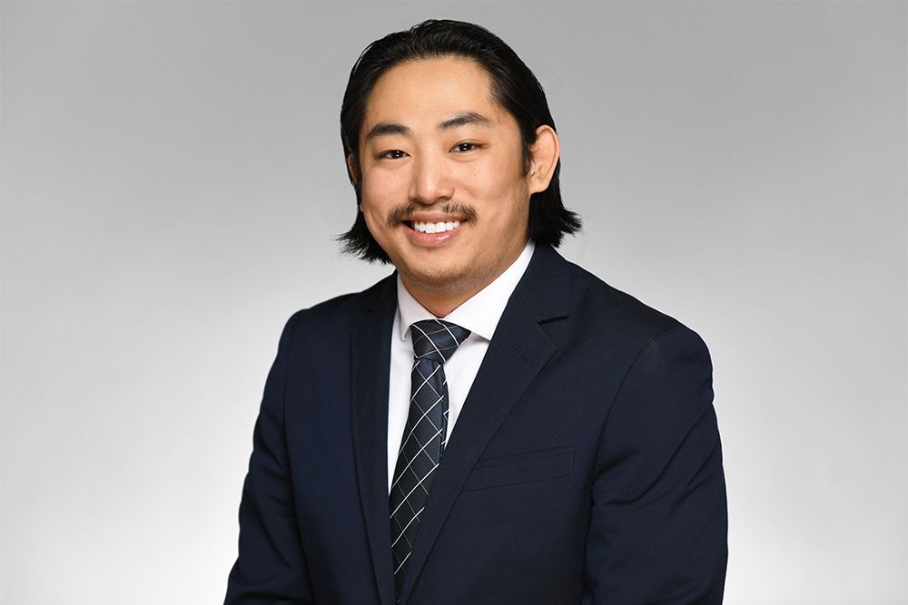 A man in a suit and tie is smiling for the camera.