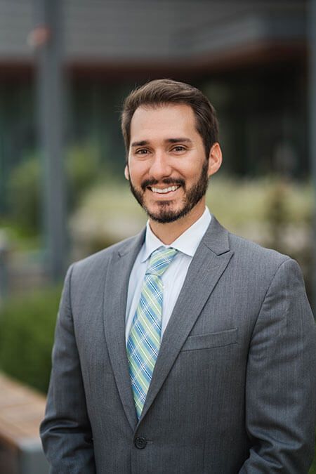 A man in a suit and tie is smiling for the camera.