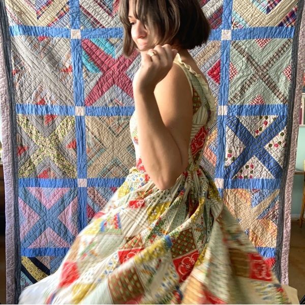 Woman twirling in vintage patchwork dress